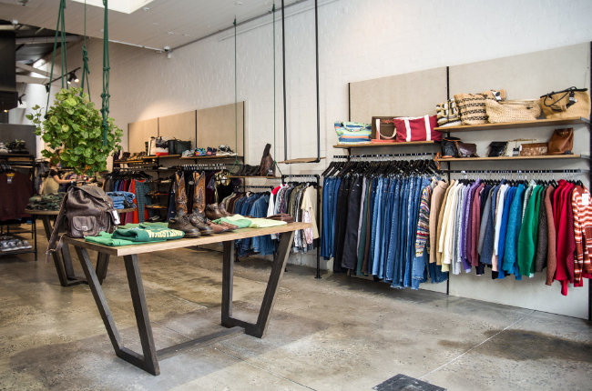 clothes folded on a table and handing on a rack